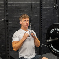 Thumbnail for Angled shot of man performing excersises with cable crossover machine stirrup attachment in gym background