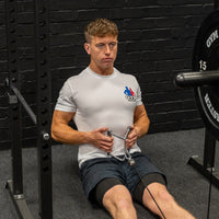 Thumbnail for Angled shot of man performing excersises with cable crossover machine stirrup attachment in gym background