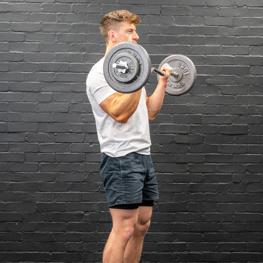 Man performing bicep curl with ez-bar barbell and gunmetal GYM MASTER weight plates
