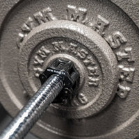 Thumbnail for Closeup shot of gunmetal GYM MASTER weight plates attached to chrome GYM MASTER barbell
