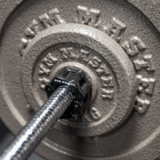 Closeup shot of gunmetal GYM MASTER weight plates attached to chrome GYM MASTER barbell